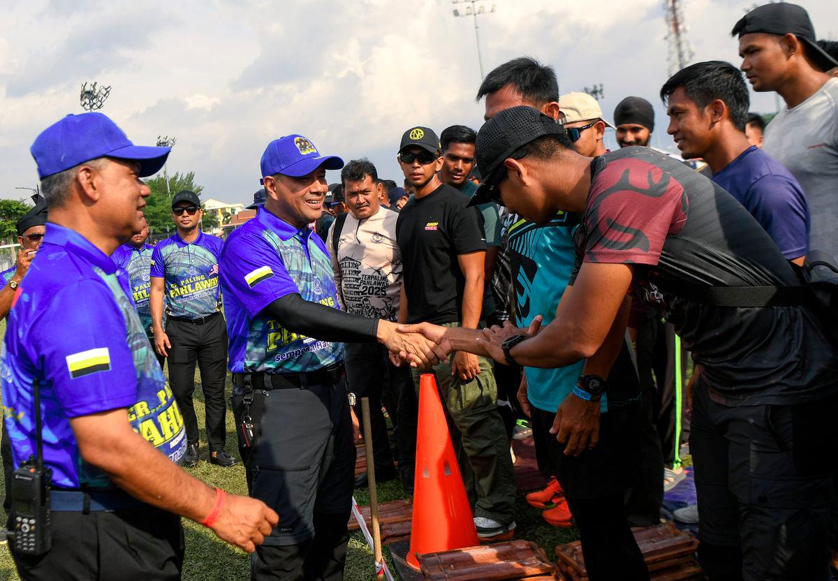 Ketua Polis Perak Datuk Noor Hisam Nordin (tengah) menyantuni anggota polis yang juga peserta ketika hadir pada perasmian Program Ter...Paling Pahlawan Challenge 2025 di Padang Speedy hari ini. Turut bersama Ketua Polis Daerah Hilir Perak ACP Dr Bakri Zainal Abidin (kiri) - fotoBERNAMA
