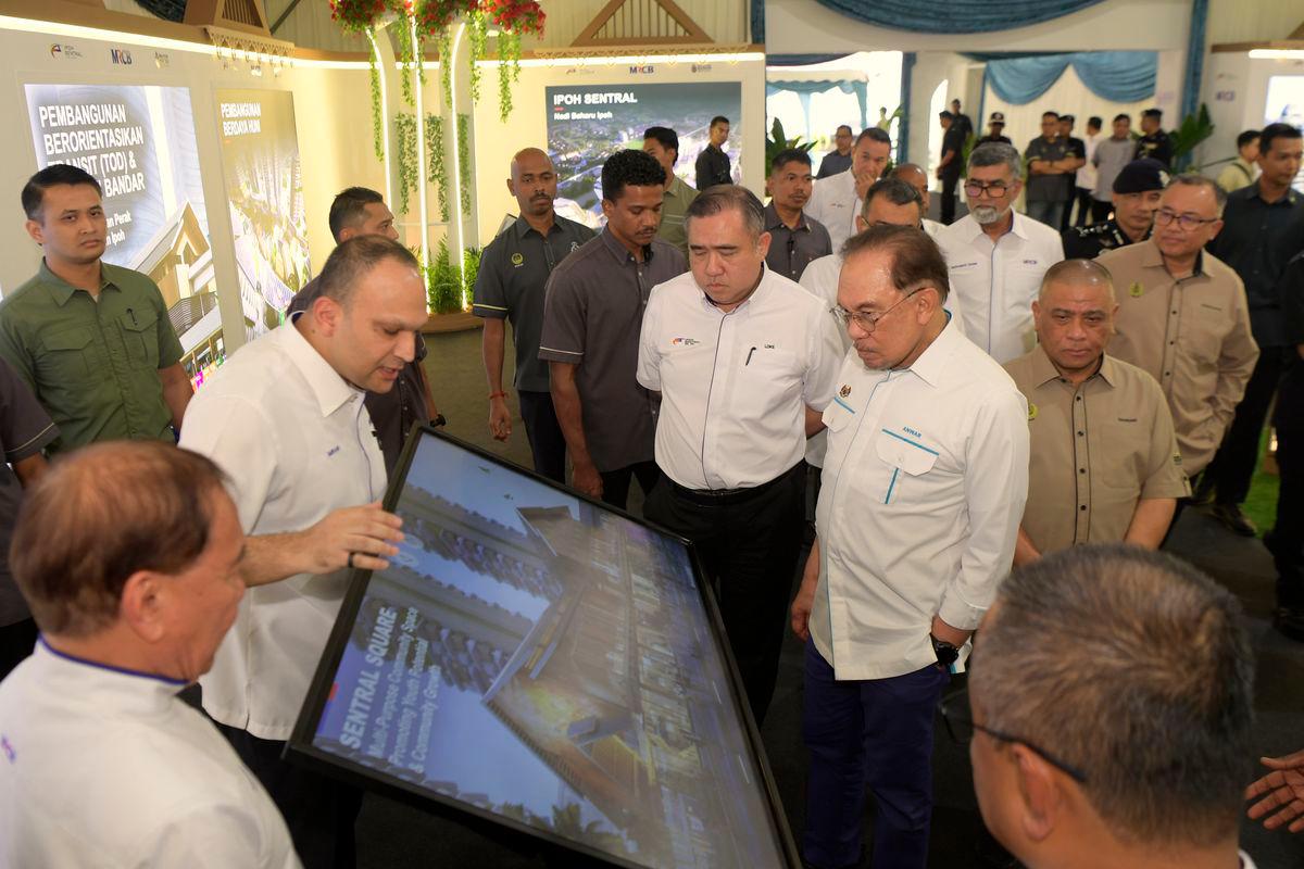 Perdana Menteri Datuk Seri Anwar Ibrahim (tiga, kanan) mendengar taklimat daripada Pengarah Urusan Kumpulan MRCB, Datuk Imran Salim (dua, kiri) ketika melawat reruai pada Majlis Pecah Tanah Pembangunan Ipoh Sentral di pekarangan Stesen Keretapi Ipoh hari ini. Turut sama Menteri Pengangkutan Anthony Loke (empat, kanan), Menteri Besar Datuk Seri Saarani Mohamad (dua, kanan) dan Pengerusi MRCB Land Sdn Bhd Tan Sri Mohd Annuar Zaini (kiri) - fotoBERNAMA