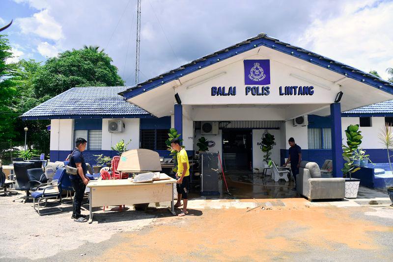 Anggota polis mengangkat barangan pejabat yang rosak selepas ditenggalami air dalam kejadian banjir ketika tinjauan di Balai Polis Lintang hari ini.- fotoBERNAMA