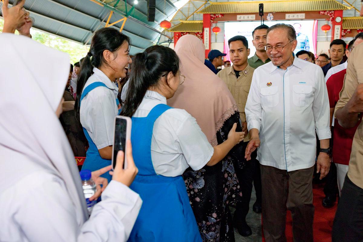 Perdana Menteri Datuk Seri Anwar Ibrahim beramah mesra bersama para pelajar pada program Majlis Sumbangan Kasih Madani sempena Deepavali 2025 di Sekolah Menengah Jenis Kebangsaan Poi Lam hari ini. - BERNAMA