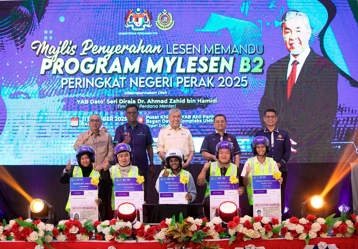 Timbalan Perdana Menteri Datuk Seri Dr Ahmad Zahid Hamidi (belakang,tiga,kiri) bergambar bersama penerima pada Majlis Penyerahan Lesen Memandu Program MyLesen B2 Peringkat Negeri Perak Tahun 2025 di Kompleks Umno Bagan Datuk di sini hari ini. Turut sama Ketua Setiausaha Kementerian Pengangkutan Malaysia Datuk Seri Jana Santhiran Muniayan (belakang,dua,kiri) Pengerusi Jawatankuasa Pembangunan Luar Bandar, Perladangan, Pertanian dan Industri Makanan negeri, Datuk Mohd Zolkafly Harun (belakang,kiri) dan Ketua Pengarah Jabatan Pengangkutan Jalan (JPJ) Datuk Aedy Fadly Ramli (belakang,empat,kiri). - BERNAMA