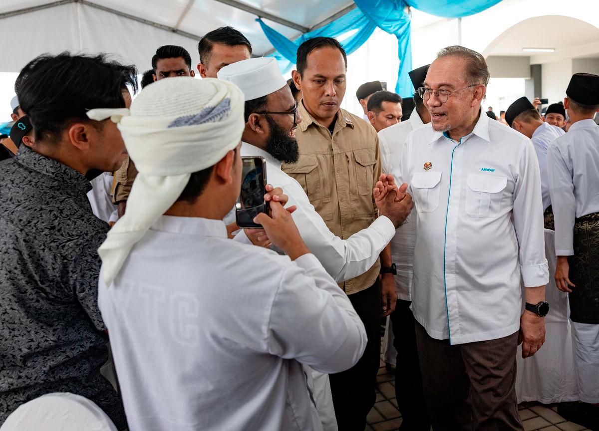 Perdana Menteri Datuk Seri Anwar Ibrahim beramah mesra bersama para tetamu pada program Kenduri Rakyat bersama Warga Institusi Pendidikan Islam Negeri Perak di Sekolah Menengah Tahfiz Darul Ridzuan hari ini. - BERNAMA