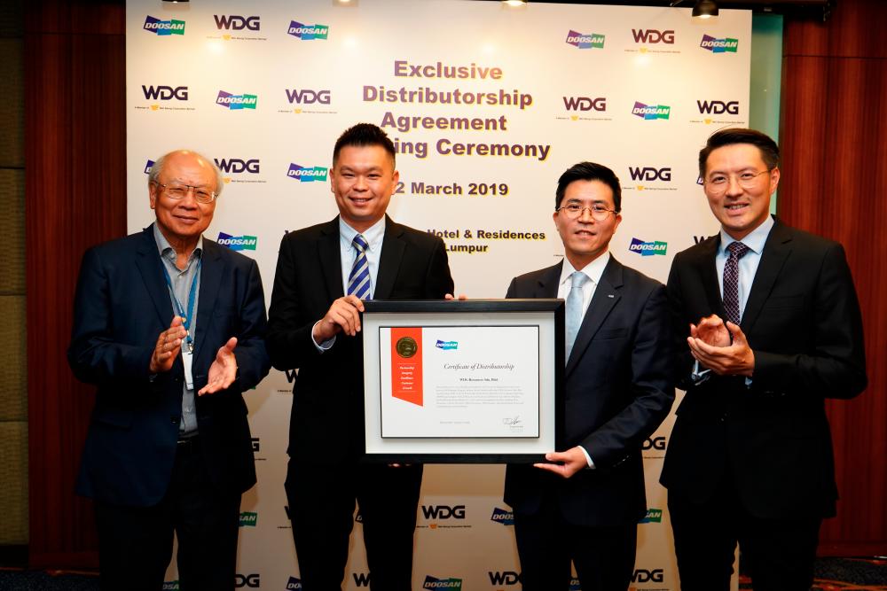 Jeong (second from right) presenting the Certificate of Distributorship to WDG vice president and director Danny Ang (second from left). Looking on are (from left) Chan and Wah Seong CEO of industrial trading and services division Goh Eng Hooi.