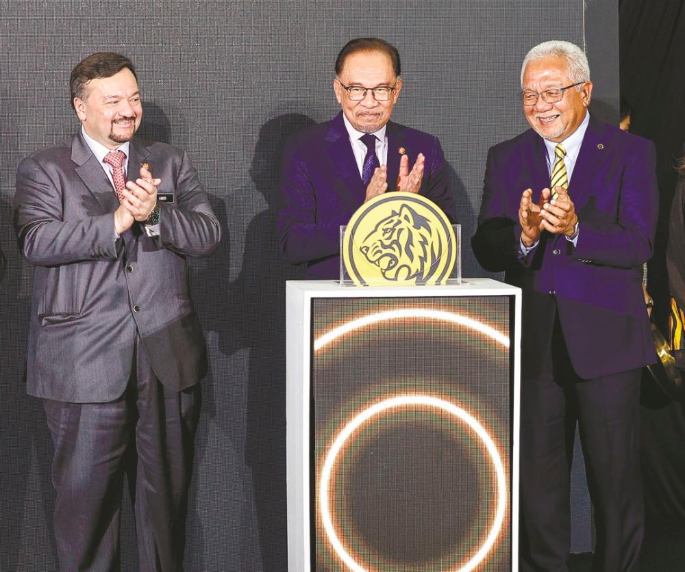 Anwar (centre), Finance Minister II Datuk Seri Amir Hamzah Azizan (left) and Maybank Group chairman Tan Sri Zamzamzairani Mohd Isa at the launch of myimpact SME Hub. – BERNAMAPIC