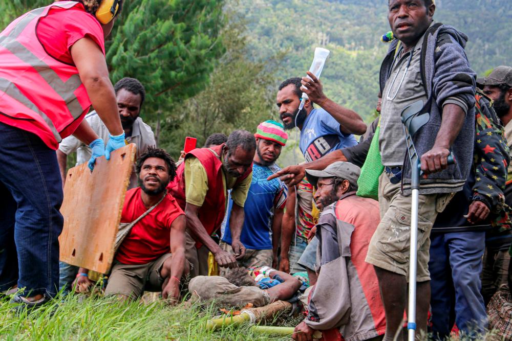This handout photo taken and received from Manolos Aviation on September 11, 2022, shows an injured villager (bottom C) being prepared for evacuation by helicopter from Kombul village to the nearby the city of Lae following a 7.6-magnitude earthquake which struck off Papua New Guinea's coast. - AFPPIX