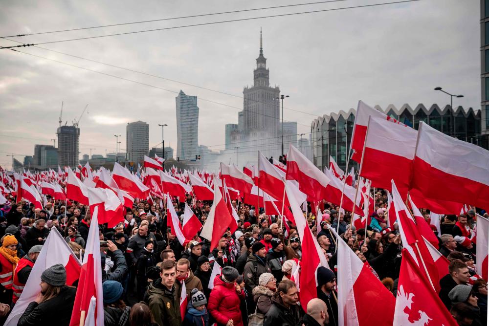People wave national flags during a march to mark Poland's National Independence Day on Nov 11 in Warsaw. — AFP