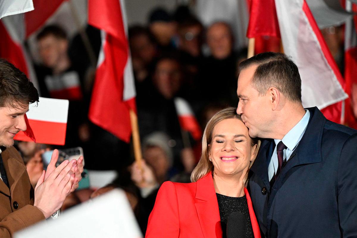 Karol Nawrocki (R), candidate for the 2025 Polish presidential election supported by Poland’s right-wing Law and Justice (PiS) party, kisses his wife Marta (C) as his son Daniel (L) applauds during a campaign rally in Stalowa Wola on May 16, 2025, ahead of the first round of the May 18 presidential elections