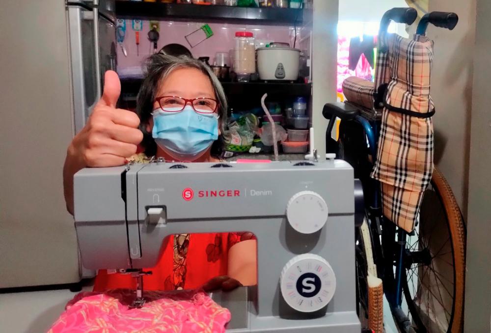 Polio survivor Yee Pen Yeng, 57 tries her brand new Singer sewing machine. A donor decided to donate her RM 2,000 to purchase the equipment after reading her wish to earn a living as a seamstress. -SYED DANIAL/THESUN