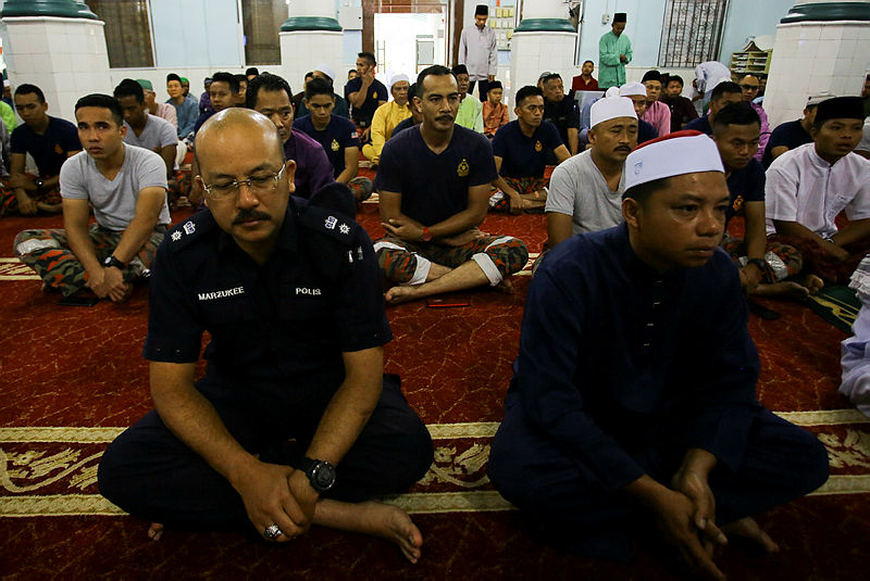 Nilai district police chief Supt Mohd Nor Marzukee Besar (L) performs Aidiladha prayers at the Masjid Kariah Pantai, Seremban at 7am, on Aug 11, 2019.