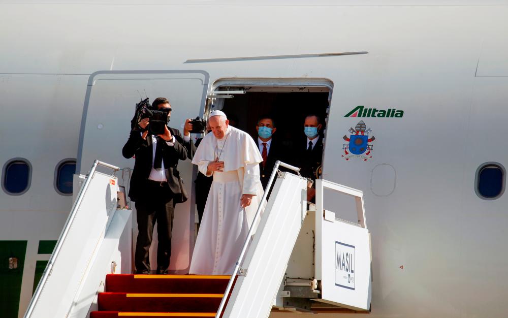 Pope Francis gestures as he boards a plane to depart for Rome, at Baghdad International Airport in Baghdad, Iraq March 8, 2021. — Reuters