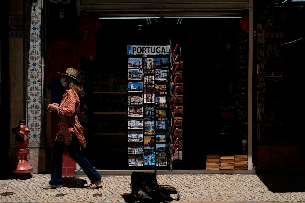 A woman wearing a protective mask walks in Lisbon downtown amid the coronavirus disease (Covid-19) pandemic, in Lisbon, Portugal, June 24, 2021. — Reuters