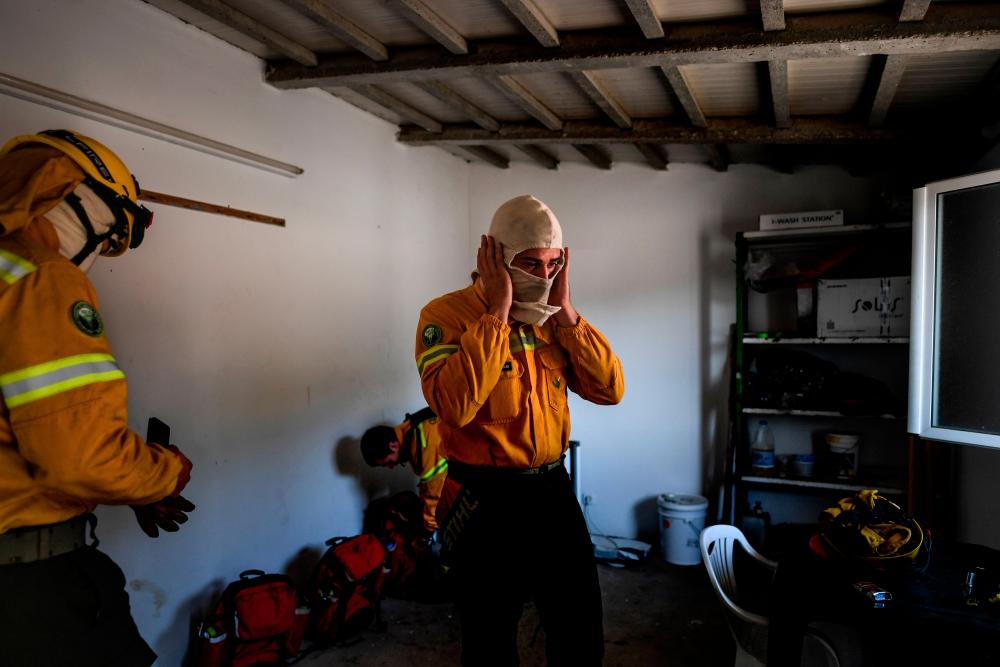 File photo taken on Aug 30 shows private firefighters from Afocelca, get ready before a drill at Constancia in Abrantes, central Portugal. — AFP