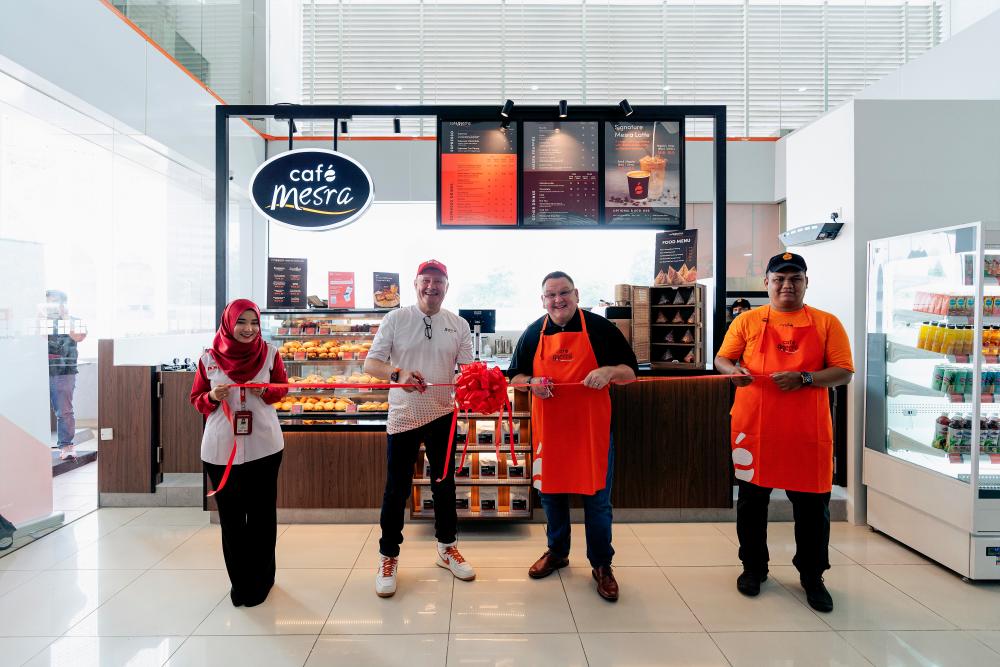 Cruddas (second from left) and Brewer (second from right) launching the Café Mesra outlet at the Kuala Lumpur General Post Office at Dayabumi.