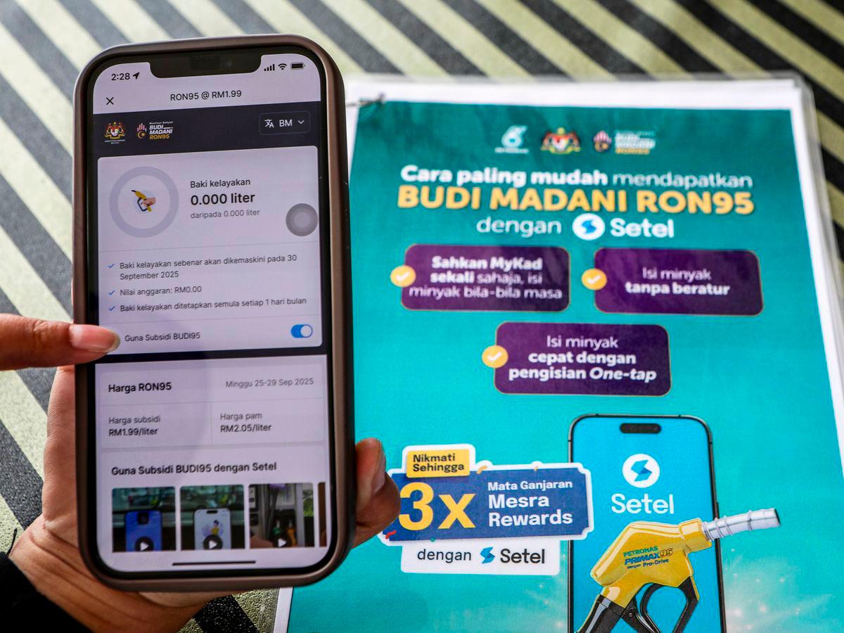 Kakitangan Stesen Minyak Petronas menunjukkan cara menggunakan aplikasi Setel sebagai persiapan pelaksanaan BUDI95 yang bakal bermula tidak lama lagi di stesen minyak Petronas Jejawi semalam- BERNAMA