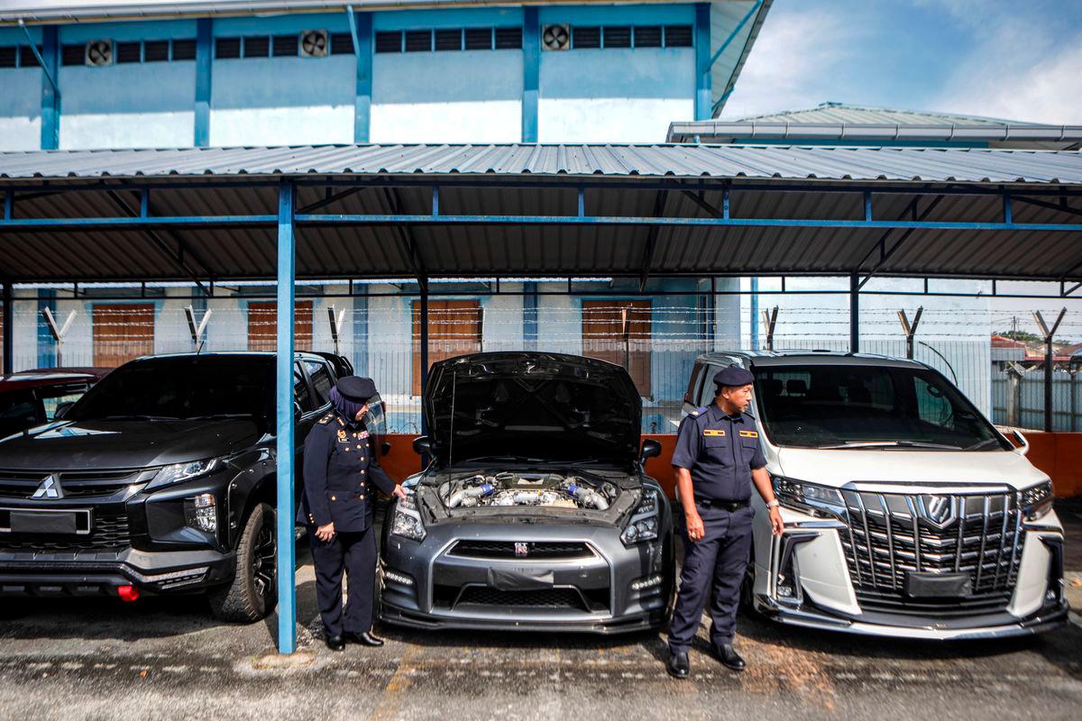 Pengarah Jabatan Pengangkutan Jalan (JPJ) Perlis, Noraini Mohd Nawi (kiri) melihat antara kenderaan mewah jenis Nissan GTR R35 dan Alphard milik ahli perniagaan yang disita ketika sidang media Ops Luxury di Ibu Pejabat JPJ Perlis- BERNAMA