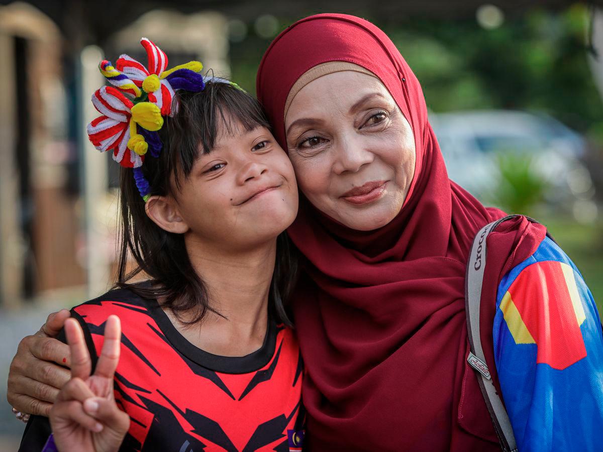 Rusliza Ahmad, 54, bersama anaknya Nur Hajar Alwi, 14, ketika ditemui pada Program Semarak Merdeka bersama Orang Kurang Upaya (OKU) Pertubuhan Pemulihan Dalam Komuniti (PDK) Jauhar Jannah sempena sambutan Hari Kebangsaan ke-68 di Sadiah Kafe, Wang Ulu di sini. - BERNAMA