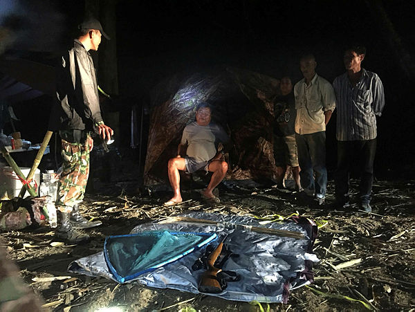 Thai tycoon Premchai Karnasuta (C) being arrested by authorities for poaching in the Thungyai Naresuan national park in Kanchanaburi province. — AFP