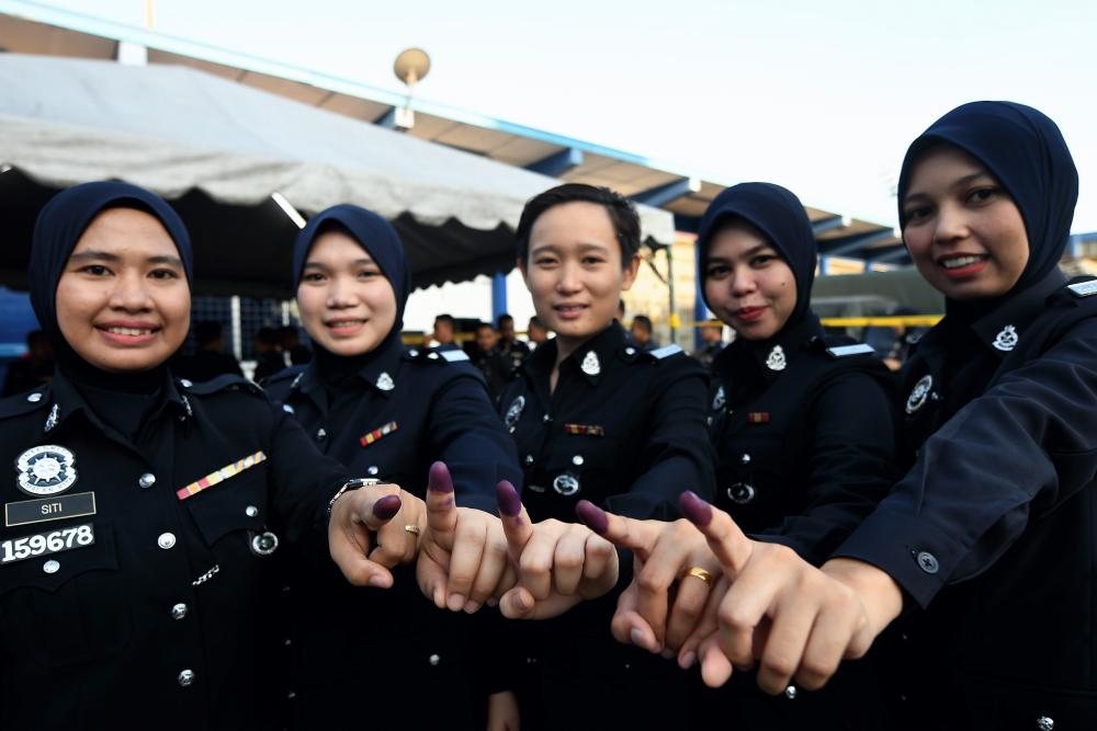 Police officer (from L) Siti Mariam Mat Yaatim, 34, Nazatul Hazwani Othman, 26, Steffi Teo Chu Ling, 24, Siti Khadijah Mohd Nosi, 27, and Syafiah Ismail, 32, show their finger dipped in permanent ink after casting their vote for the N24 Semenyih State Legislative Assembly (by-election) at the Kajang District Police Headquarters (IPD), on Feb 26, 2019. — Bernama