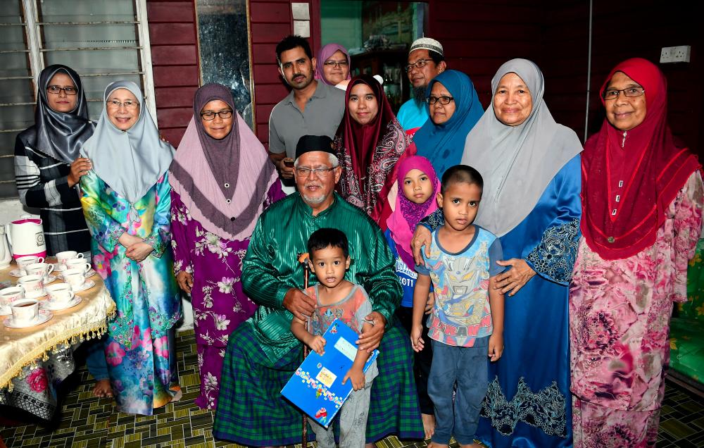 Deputy Prime Minister Datuk Seri Dr Wan Azizah Wan Ismail (L2) pose for a picture with the family of Ibrahim Khamis, 66, (C, seated) during a visit to Kampung Batu 4, 3/4, Mambau, Seremban on April 2, 2019. — Bernama