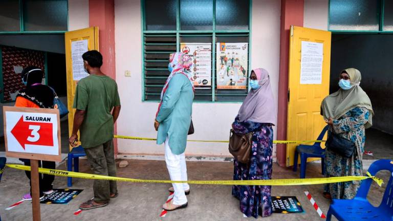 Voters followed the social distancing procedure during the voting process for the Chini By-election at the Quran dan Fardu Ain Classes (Kafa) in Felda Chini 3 yesterday. — Bernama