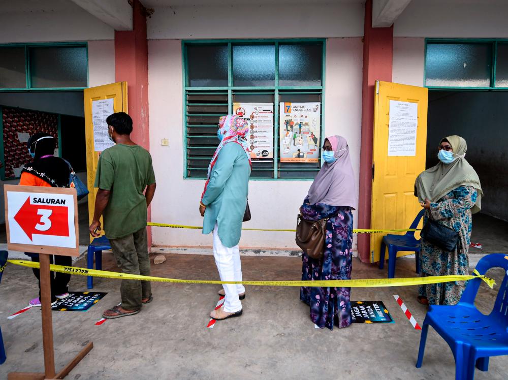Voters followed the social distancing procedure during the voting process for the Chini By-election at the Quran dan Fardu Ain Classes (Kafa) in Felda Chini 3 today. — Bernama