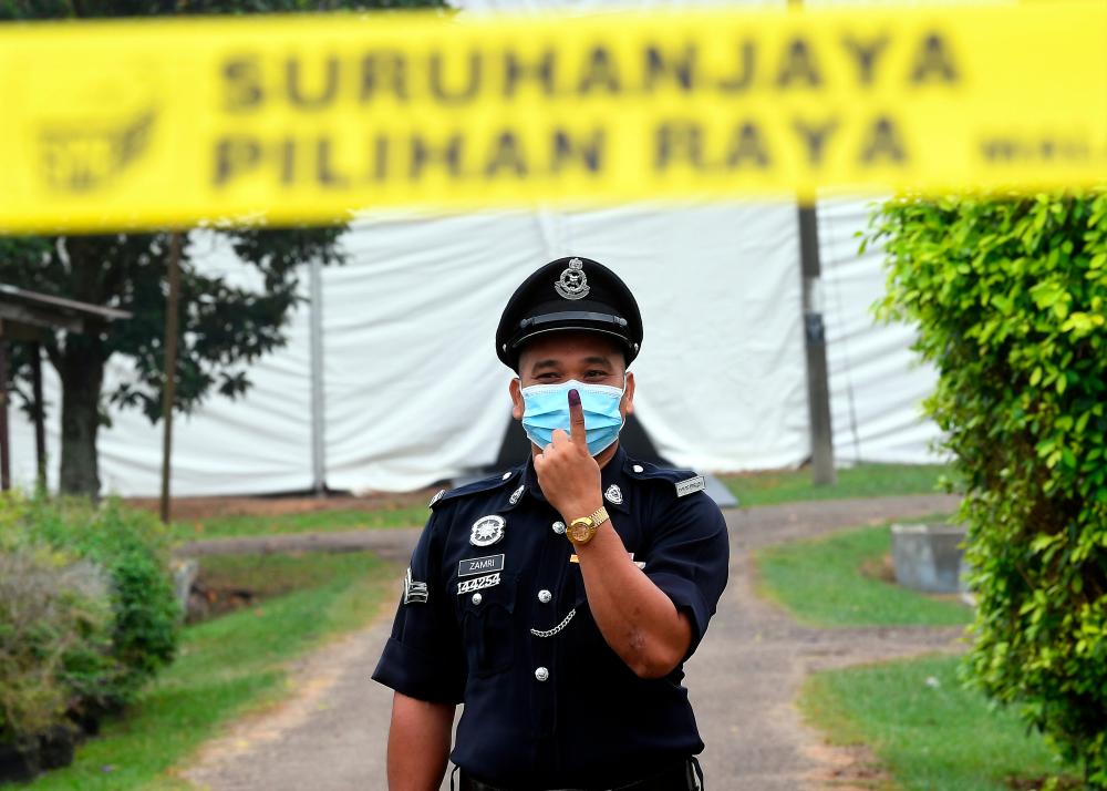 Corporal Zamri Mohamad, 40, showed off his finger after voting early for the Chini by-election in the Chini police station today. - Bernama