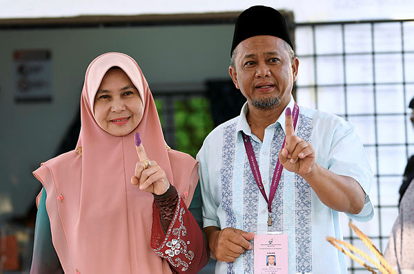 BN candidate Zakaria Hanafi, with his wife Katijah Beebi Bayi Khan, show off the permanent ink on their fingers after they cast their votes in the Semenyih state legislative seat by-election at JKKK Kampung, Sesapan Kelubi on March 2, 2019. — Bernama