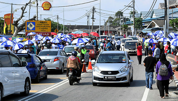 Traffic flow is tight due to the crowds of voters standing on the left and right side of the road during the Rantau by-election on April 13, 2019. — Bernama