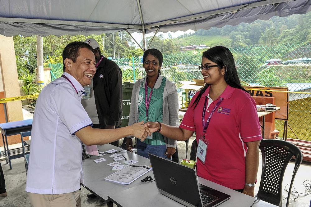 Election Commission (EC) chairman Azhar Azizan Harun (L) greets the EC staff at the polling centre during the P078 by-election on Cameron Highlans in Sekolah Kebangsaan Ringlet, on Jan 26, 2018. — Bernama