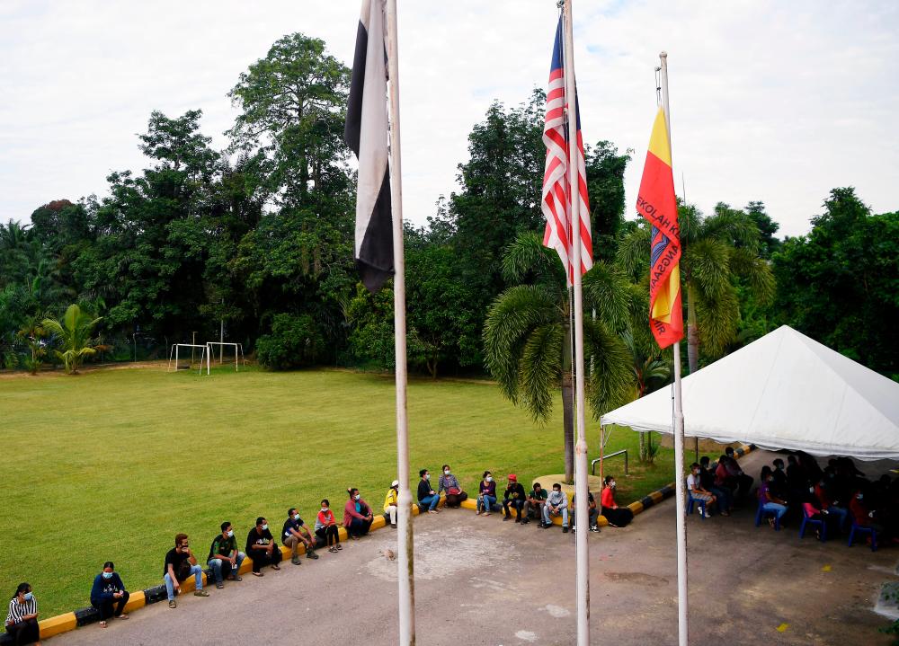 Orang Asli practise social distancing while waiting for their turn to vote at Sekolah Kebangsaan Kinchir for the Chini state by-election today. - Bernama