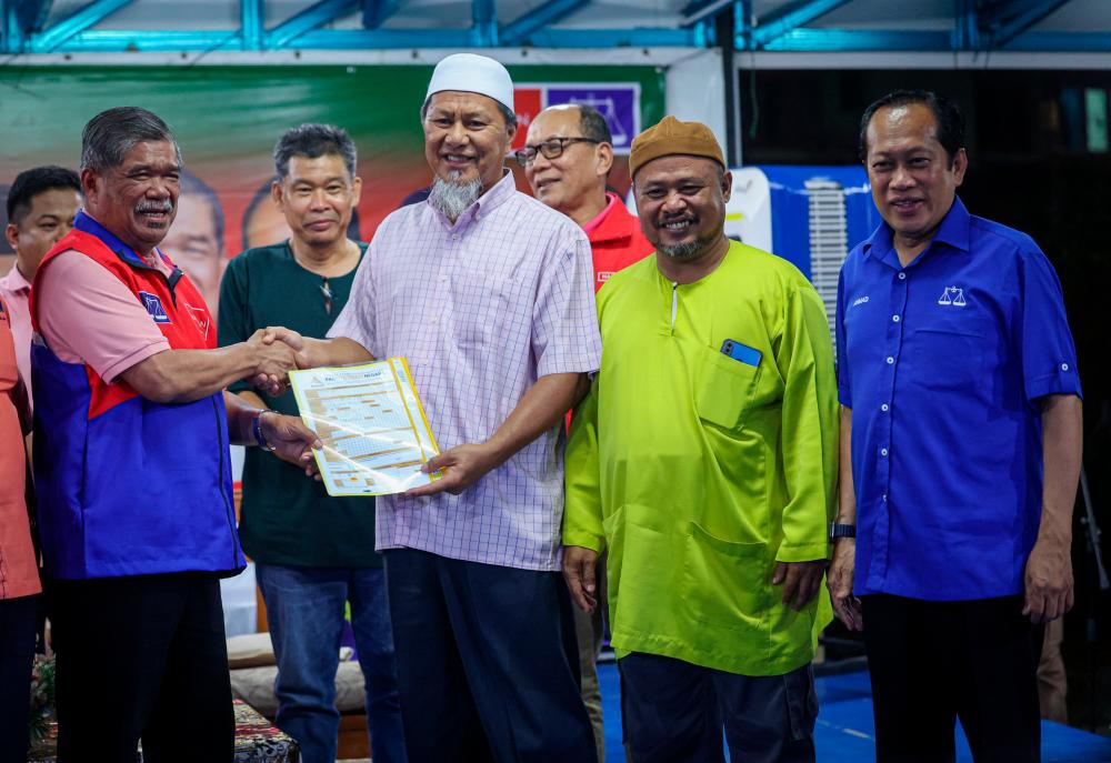 MUAR, 2 Sept -- Presiden Parti Amanah Negara (AMANAH) Datuk Seri Mohamad (kiri) menerima borang keahlian daripada bekas Adun Pas Bukit Pasir, Najib Lep (tiga kanan) pada Ceramah Kolompok Perpaduan sempena Pilihan Raya Kecil (PRK) N.13 Dewan Undangan Negeri DUN Simpang Jeram di Taman Desa, Muar - fotoBERNAMA