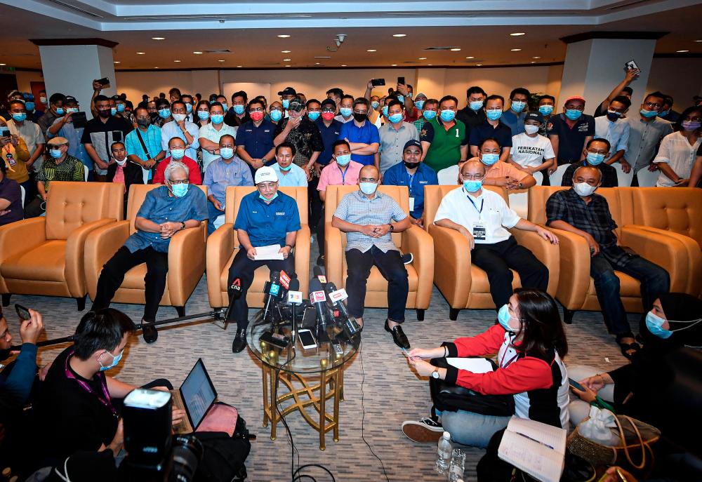 Sabah Bersatu Chief Datuk Hajiji Noor (seated second, left) with PN Secretary-General also Home Minister Datuk Seri Hamzah Zainuddin (seated, left) during a press conference after the current Sabah state election results here today. Also present Bersatu Vice President Datuk Seri Dr Ronald Kiandee (seated second, right). — Bernama
