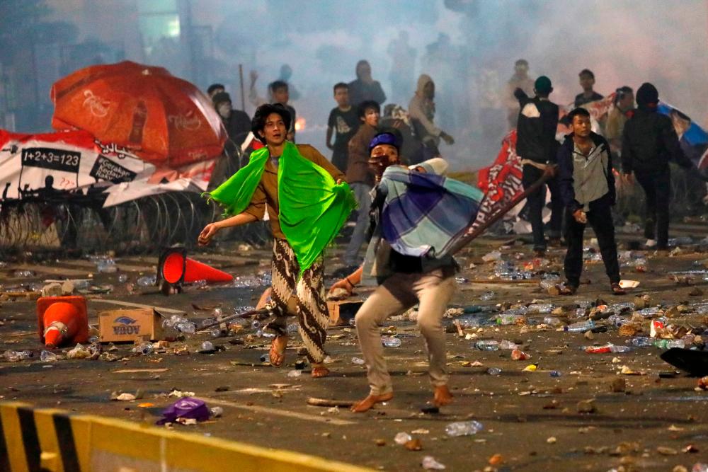 Protesters hurl stones during a riot near the Election Supervisory Agency (Bawaslu) headquarters in Jakarta, Indonesia, May 22, 2019. — Reuters