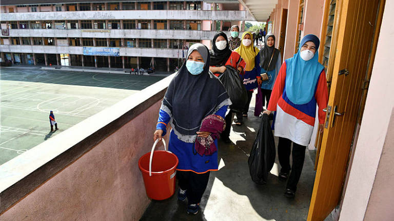 Parents and teachers of SK Taman Pasir Putih conduct clean up efforts following the chemical leak on Thursday. — Bernama