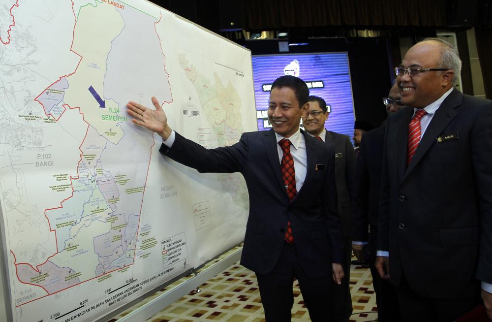 Election Commission Chairman (EC) Azhar Azizan Harun (L) is seeing a map with Semenyih State Legislative Assembly (PRK) chairman Datuk Mohd Sayuthi Bakar (R) after holding a press conference at Menara SPR, on Jan 18, 2019. — Bernama