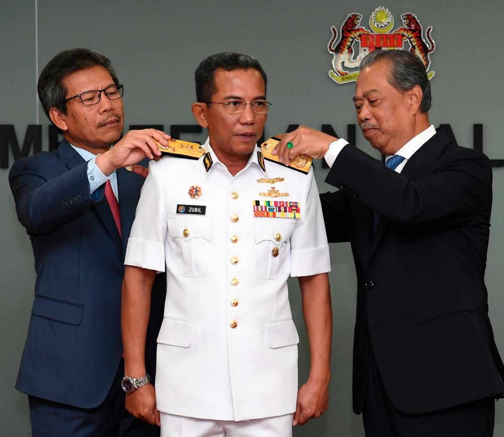 Home Minister Tan Sri Muhyiddin Yassin (R) and Home Ministry Secretary-General Datuk Seri Alwi Ibrahim (L) personally appoint and promote Maritime Admiral Datuk Mohd Zubil Mat Som as the new MMEA DG at the Home Ministry today. - Bernama