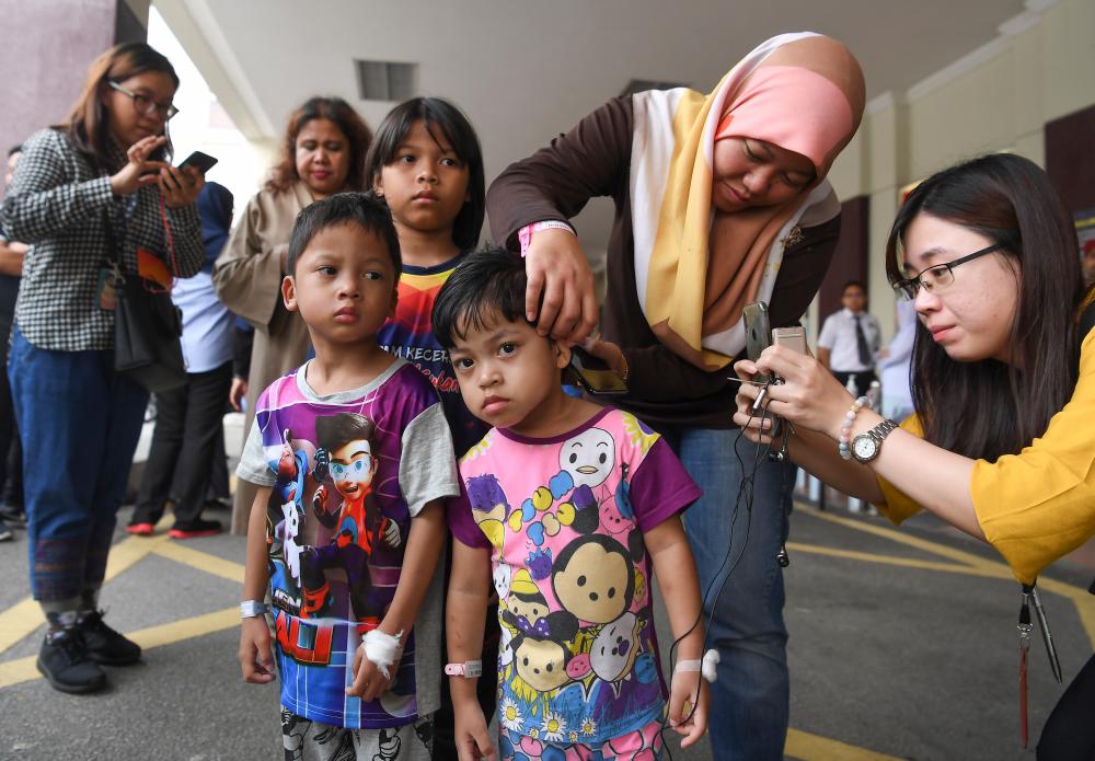 Sri Rahayu Sugiono (2nd R) shows the scalding suffered by her son Mohd Haffizal Khalid, 5, following a helium balloon explosion, on Oct 12, 2019. — Bernama