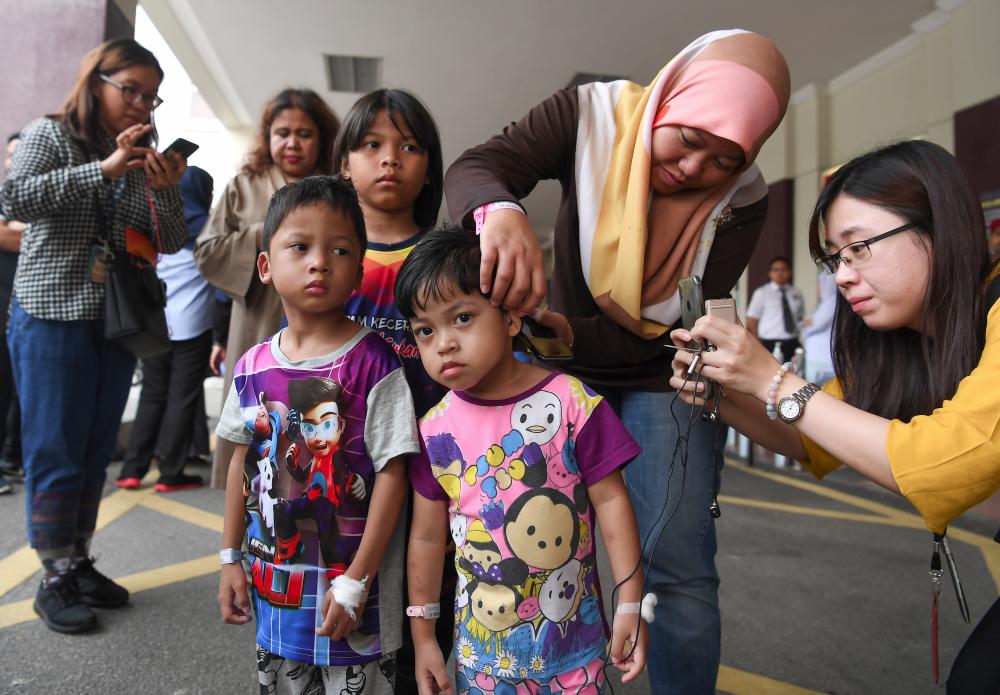 Filepix taken on Oct 12 shows Sri Rahayu Sugiono showing burns on her daughter Nur Haffiqah Khalid (C), 4, after her family were released from Putrajaya Hospital after being hit by a helium balloon blast. — Bernama