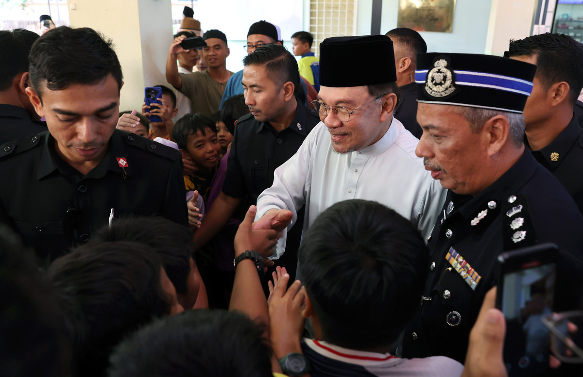 Perdana Menteri Datuk Seri Anwar Ibrahim (tengah) beramah mesra dengan kanak-kanak selepas menunaikan solat Jumaat di Surau Al-istiqlal Presint 14 hari ini. - BERNAMA