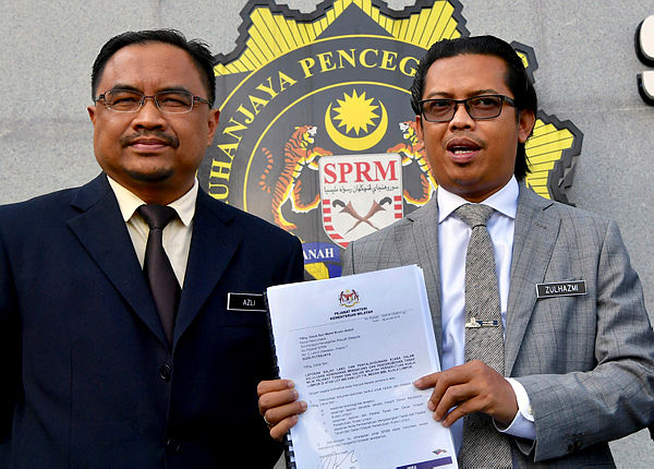 Special Functions Officer to the Minister, Zulhazmi Shariff (R) displays a report on the trespassing of two lots in Medan Imbi, Bukit Bintang before handed them over to the MACC, on Jan 23, 2019. — Bernama