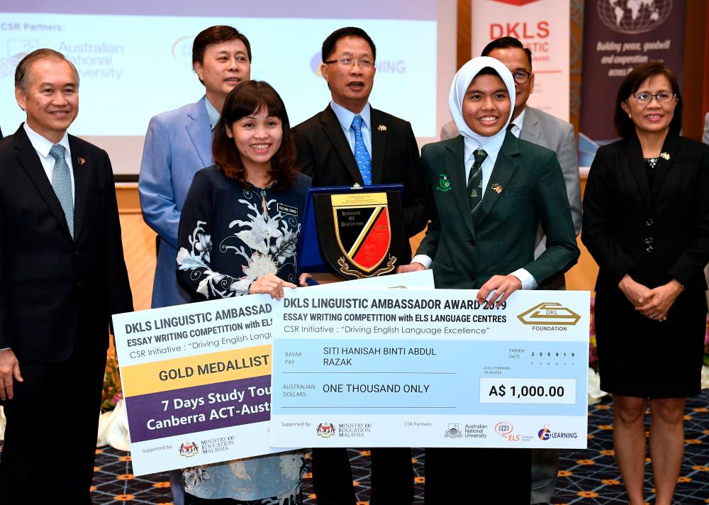 Deputy Education Minister Teo Nie Ching (front left) presents the essay writing winners prize to Siti Hanisah Abdul Razak (front right), during the essay writing competition, ‘DKLS Linguistic Ambassador Award’, on Sept 20, 2019. — Bernama