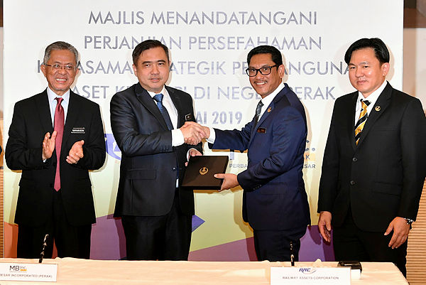 Transport Minister Anthony Loke (2nd from L) receives a souvenir from Perak Mentri Besar Datuk Seri Ahmad Faizal Azumu (2nd from R) after witnessing the signing of a MoU on the development of the railway assets in Perak. — Bernama