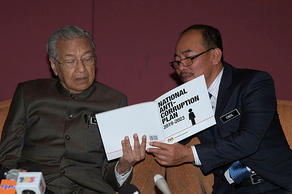 Prime Minister Tun Dr Mahathir Mohamad (L) peruses the NACP with Chief Secretary to the Government Datuk Seri Dr Ismail Bakar. — Bernama