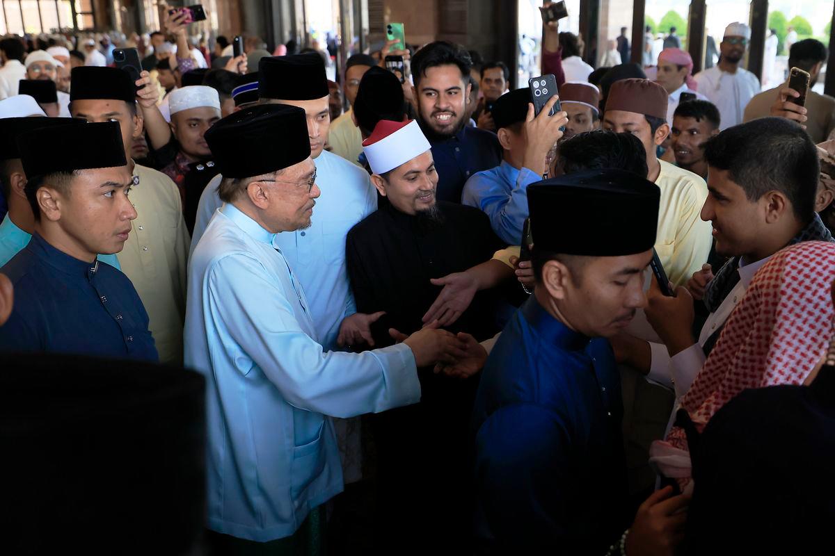 Perdana Menteri Datuk Seri Anwar Ibrahim bersalaman bersama orang ramai selepas hadir menunaikan solat sunat Aidiladha di Masjid Putra hari ini. fotoBERNAMA