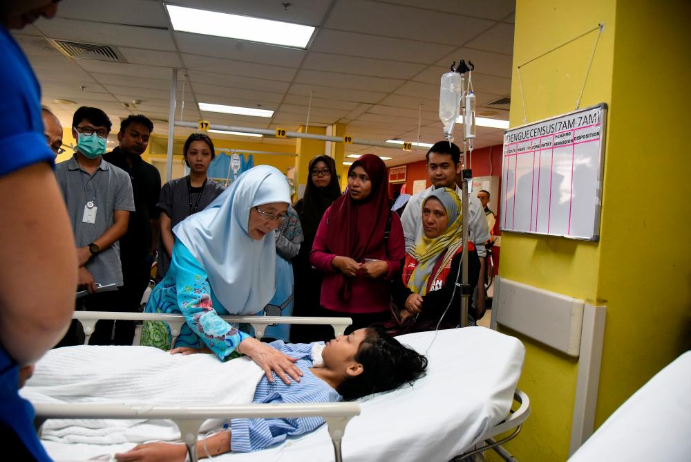 Deputy Prime Minister Datuk Seri Dr Wan Azizah Wan Ismail checks on a victim of the helium gas inflated balloons explosion, at the Putrajaya Hospital, on Oct 12, 2019. — Bernama