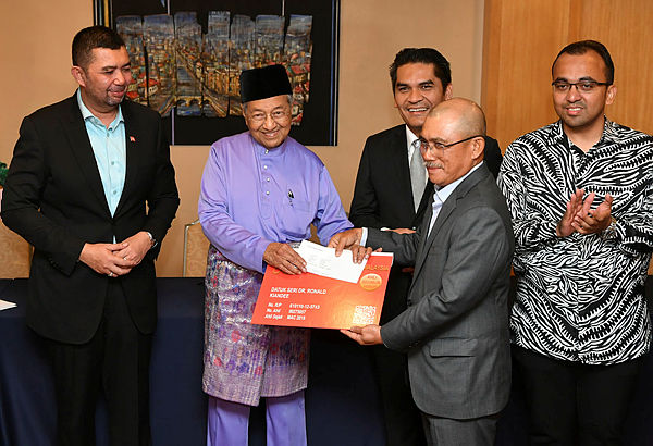 Prime Minister and Bersatu chairman Tun Dr Mahathir Mohamad presents Bersatu membership cards to eight former Umno members at the Perdana Leadership Foundation, Putrajaya on March 15, 2019. — Bernama