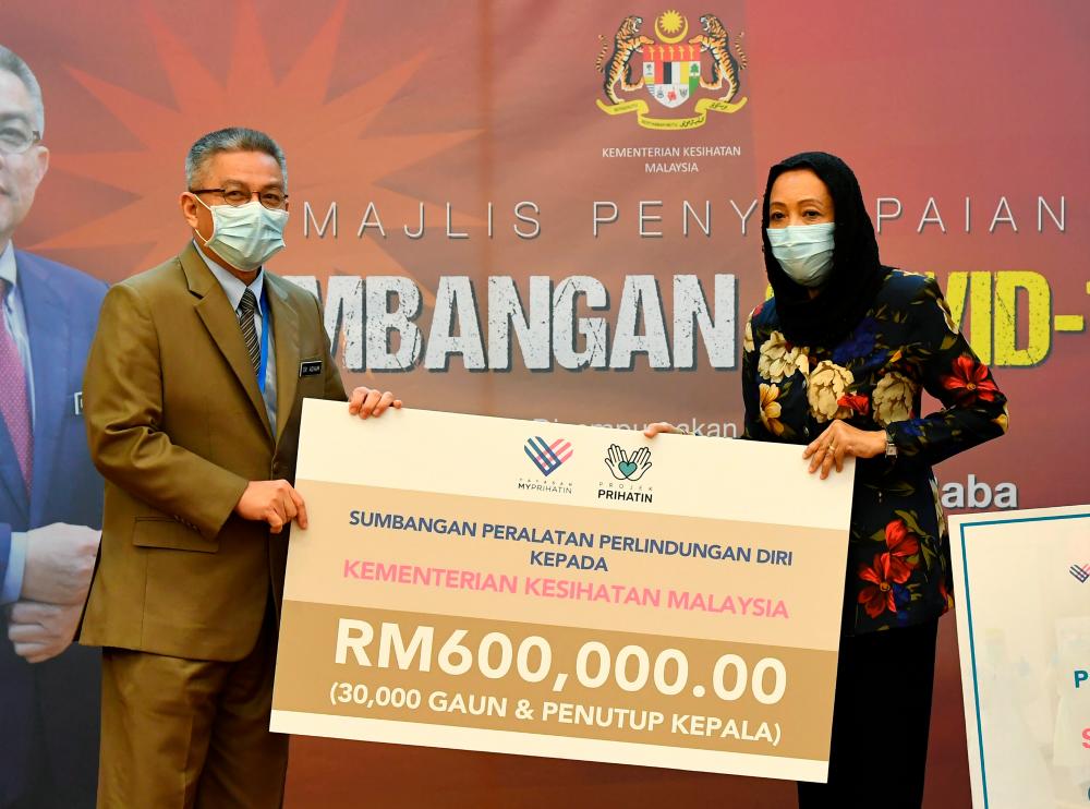 Health Minister Datuk Seri Dr Adham Baba (L) receives a donation of RM600,000 worth of PPPE from the MyPrihatin Foundation presented by its chairman Prof Datuk Halimaton Hamdan at the Covid-19 Fund donation ceremony at the Ministry of Health today. - Bernama