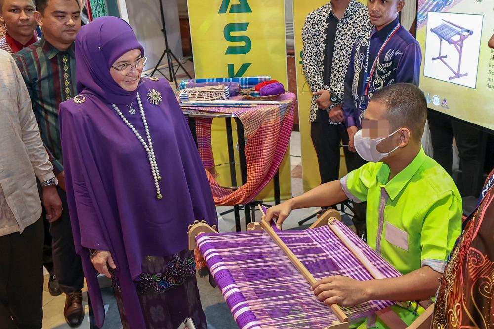 Raja Permaisuri Agong Tunku Hajah Azizah Aminah Maimunah Iskandariah berkenan melihat penghuni penjara menenun songket semasa majlis Malam Simfoni Kasih 2023 Jabatan Penjara Malaysia di sini pada malam Dis 27 2023. - fotoBERNAMA