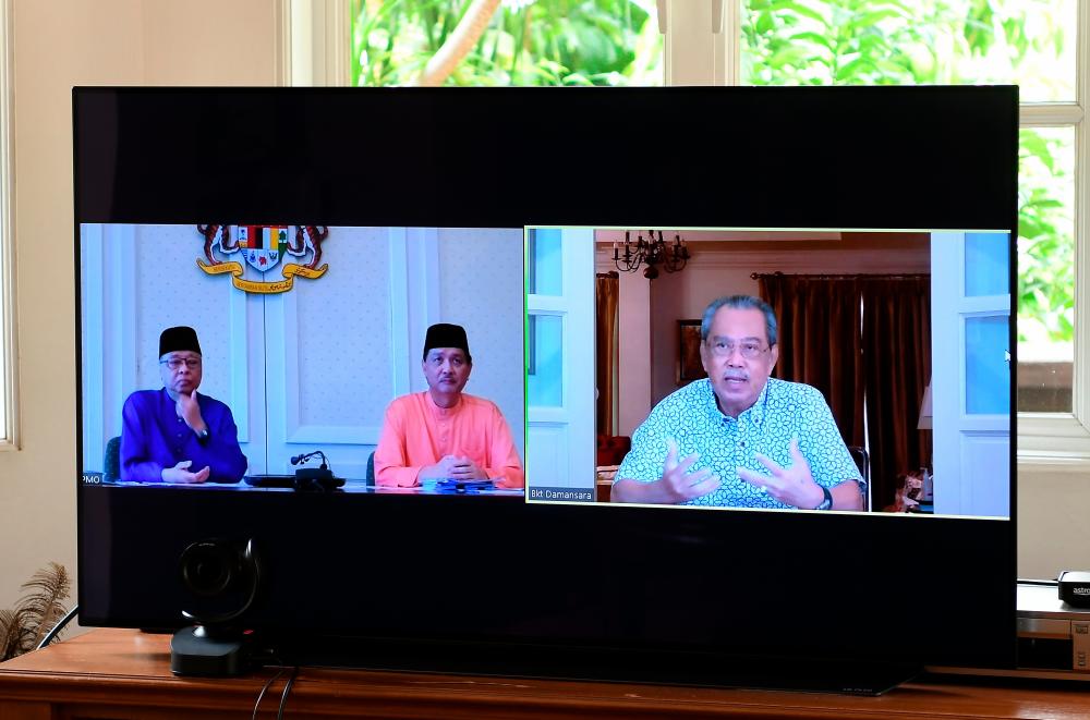 Prime Minister Tan Sri Muhyiddin Yassin at a video conference with Senior Minister Datuk Seri Ismail Sabri Yaakob (L) and Health Director-General Datuk Dr Noor Hisham Abdullah today. - Bernama