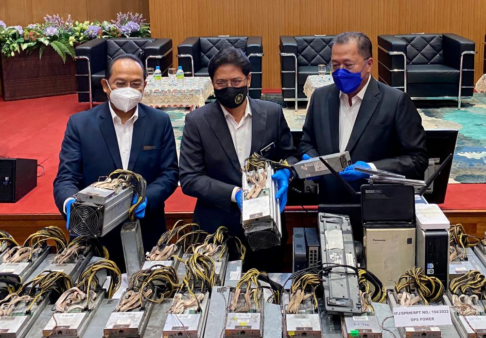 PUTRAJAYA, March 1 - Malaysian Anti -Corruption Commission (MACC) Chief Commissioner Tan Sri Azam Baki (center) looks at a bitcoin mining machine during a press conference on Ops Power at the MACC Putrajaya Headquarters. BERNAMApix